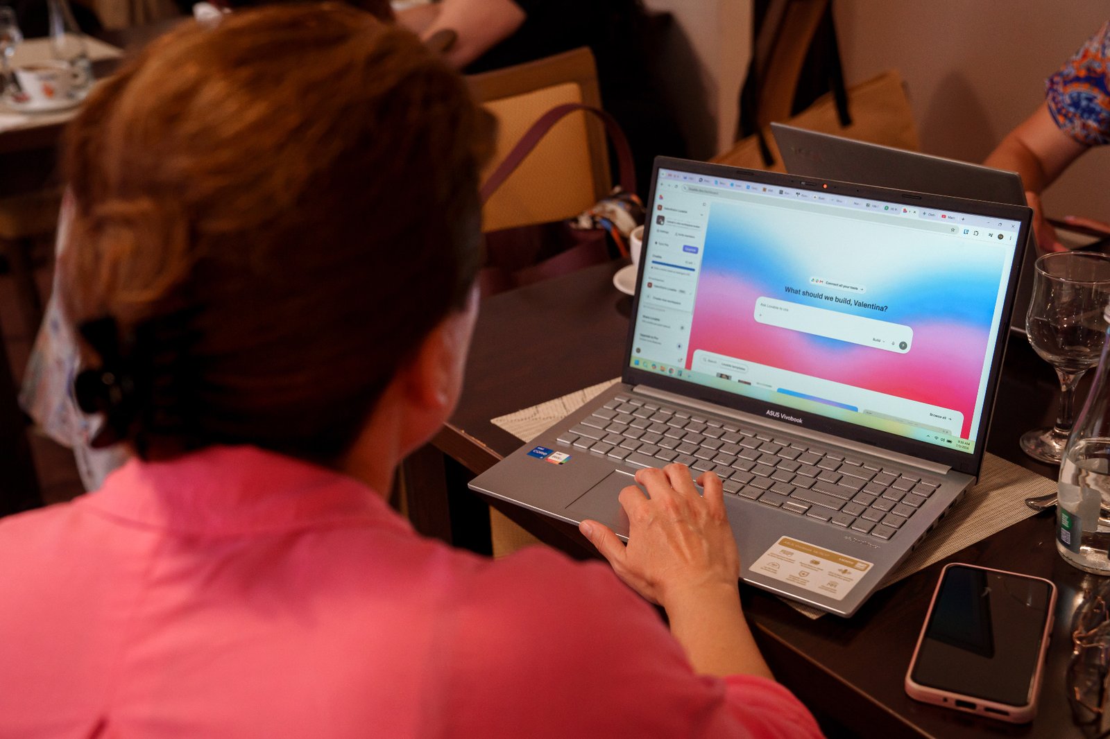 Fotografie de la un eveniment Black Sea Vibes: o participantă lucrează pe laptop în interfața Lovable, într-un spațiu cald și colaborativ